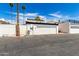 Garage exterior with desert landscaping, complemented by palm trees and a clear blue sky at 7684 E Minnezona Ave, Scottsdale, AZ 85251