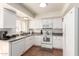 Well-lit kitchen with white cabinets, stainless steel appliances, and tile floors at 7684 E Minnezona Ave, Scottsdale, AZ 85251