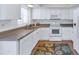 Bright kitchen featuring white cabinetry, stainless steel appliances, and a stylish decorative rug at 7684 E Minnezona Ave, Scottsdale, AZ 85251