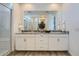 Bright bathroom featuring double sinks with a large mirror and a glass-enclosed shower with marble-look tile at 8035 E Paloma Ave, Mesa, AZ 85212