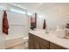 Bright bathroom featuring single sink vanity, quartz countertop, and tiled bathtub at 8142 E Petra Ave, Mesa, AZ 85212