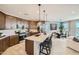 Spacious kitchen flows into dining and living areas, featuring stainless steel appliances and island seating at 8142 E Petra Ave, Mesa, AZ 85212