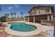 The backyard features a beautiful pool, palm trees, and a covered patio at 8469 W Emile Zola Ave, Peoria, AZ 85381