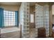 Bathroom features a tiled shower with glass blocks and a separate tub with a window at 8469 W Emile Zola Ave, Peoria, AZ 85381