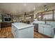 Open-concept kitchen featuring an island, stainless steel appliances, white cabinets, and hardwood flooring at 8469 W Emile Zola Ave, Peoria, AZ 85381