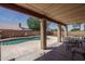 A covered patio with table and chairs overlooks the pool at 8469 W Emile Zola Ave, Peoria, AZ 85381