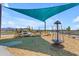 Outdoor playground with blue sunshade, climbing structure, and spinning carousel at 919 W Peralta Pass, Apache Junction, AZ 85120