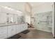 Bright bathroom featuring double sinks, granite countertops, a glass enclosed shower with marble surround and river rock base at 9571 N 117Th St, Scottsdale, AZ 85259