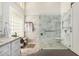 Bathroom featuring glass enclosed shower with pebble base, marble surround, and a convenient bench at 9571 N 117Th St, Scottsdale, AZ 85259