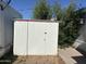 Exterior view of a shed with white siding, red trim, and a metal roof at 9913 E Main St # 40, Mesa, AZ 85207