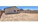 A view of a spacious backyard with dirt landscaping, a covered patio, and block wall fencing at 10430 E Sunflower Ln, Florence, AZ 85132