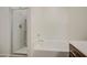 Bathroom featuring a bathtub and a glass-enclosed shower with tiled walls and chrome fixtures at 10430 E Sunflower Ln, Florence, AZ 85132