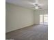Living room featuring neutral paint, new carpet, a ceiling fan, and patio door access at 10430 E Sunflower Ln, Florence, AZ 85132