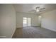 Living room featuring neutral paint, new carpet, a ceiling fan, and patio door access at 10430 E Sunflower Ln, Florence, AZ 85132