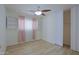 Bright bedroom featuring light wood floors, a ceiling fan, and large windows for natural light at 1125 E Milada Dr, Phoenix, AZ 85042