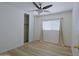 A bright bedroom featuring wood floors, a ceiling fan, and a large window for natural light at 1125 E Milada Dr, Phoenix, AZ 85042