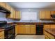 Updated kitchen with sleek black appliances, laminate floors, wood cabinets, and black sink at 1125 E Milada Dr, Phoenix, AZ 85042