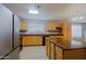 Well-lit kitchen features wood cabinets, laminate floors, island, and stainless steel appliances at 1125 E Milada Dr, Phoenix, AZ 85042