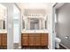 Bathroom featuring wood vanity, a large mirror, and a toilet at 11510 E Lomita Ave, Mesa, AZ 85209