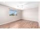 A bright bedroom with wood floors and a large window overlooking the neighborhood at 11510 E Lomita Ave, Mesa, AZ 85209