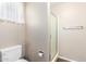 Bright bathroom featuring a stand-up shower behind a glass enclosure and a modern toilet at 11510 E Lomita Ave, Mesa, AZ 85209