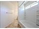 This bathroom has a tub with white tile surround, a window, and neutral tile flooring at 12679 W Lowden Rd, Peoria, AZ 85383