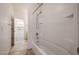 Bright bathroom featuring a white tub and shower, tile surround and floors at 12679 W Lowden Rd, Peoria, AZ 85383