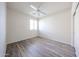 This bedroom features light, wood-look floors, a ceiling fan, and a window to let in natural light at 12679 W Lowden Rd, Peoria, AZ 85383