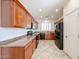 Efficient kitchen featuring wood cabinets, tile flooring, and modern appliances, all bathed in natural light at 12679 W Lowden Rd, Peoria, AZ 85383