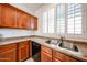Kitchen featuring wood cabinets, counterspace, a stainless steel sink, and shuttered window at 12679 W Lowden Rd, Peoria, AZ 85383
