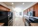 Open kitchen featuring tile flooring, cabinets, countertop, black appliances, and a refrigerator at 12679 W Lowden Rd, Peoria, AZ 85383
