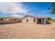Rear view of home with gravel landscaping, block wall, and covered patio at 1343 W Roadrunner Dr, Chandler, AZ 85286