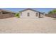 Large backyard showcasing neutral rock landscaping, a stucco home with a covered patio at 1343 W Roadrunner Dr, Chandler, AZ 85286