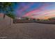 Large gravel backyard with privacy block wall under a beautiful evening sky at 1343 W Roadrunner Dr, Chandler, AZ 85286