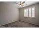 Bedroom with carpet flooring, a ceiling fan and a window with wood-style shutters at 1343 W Roadrunner Dr, Chandler, AZ 85286