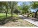 Scenic community park featuring lush green grass, mature trees, and a paved walking path on a bright sunny day at 1343 W Roadrunner Dr, Chandler, AZ 85286