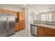 Well-lit kitchen featuring stainless steel appliances, tile flooring, and wooden cabinetry at 1343 W Roadrunner Dr, Chandler, AZ 85286