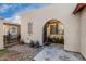 Arched entryway features an iron gate, potted plants, and a stone pathway, creating a welcoming entrance at 1602 N 73Rd Ave, Phoenix, AZ 85035