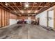 Garage featuring concrete flooring, wood walls and an electric garage door opener at 1602 N 73Rd Ave, Phoenix, AZ 85035