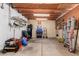 Spacious garage with exposed beam ceiling, shelving, and lots of tools, including air compressor and ladder at 1602 N 73Rd Ave, Phoenix, AZ 85035