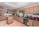 Bright kitchen features lots of cabinet storage, wood floors and an island with stainless steel countertop at 1602 N 73Rd Ave, Phoenix, AZ 85035