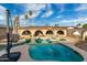 Backyard pool and patio with arched openings and palm trees, perfect for outdoor relaxation and entertaining at 1602 N 73Rd Ave, Phoenix, AZ 85035