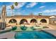 Backyard pool and spa surrounded by palm trees and an arched patio for an outdoor oasis at 1602 N 73Rd Ave, Phoenix, AZ 85035