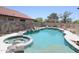 A backyard view of a spacious pool, spa, rock features, and privacy fence at 16233 N 32Nd Ave, Phoenix, AZ 85053