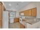 Functional kitchen featuring ample wood cabinets, white appliances and tile flooring at 1633 E Jasmine St, Casa Grande, AZ 85122