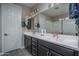 Well-lit bathroom featuring a double vanity and large mirror at 16500 W Caldwell St, Goodyear, AZ 85338