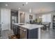 Open-concept kitchen boasts a large island with seating, stainless steel appliances, and views into the dining area at 16500 W Caldwell St, Goodyear, AZ 85338
