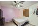 Simple bedroom with lavender-colored walls, window with blinds, and decorated with artwork at 1657 N 55Th Ave, Phoenix, AZ 85035