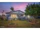 Charming single-story home featuring lush green lawn and mature trees enhancing its curb appeal at dusk at 1657 N 55Th Ave, Phoenix, AZ 85035