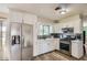 Bright kitchen features white cabinets, stainless steel appliances, and wood-look tile floors at 1657 N 55Th Ave, Phoenix, AZ 85035